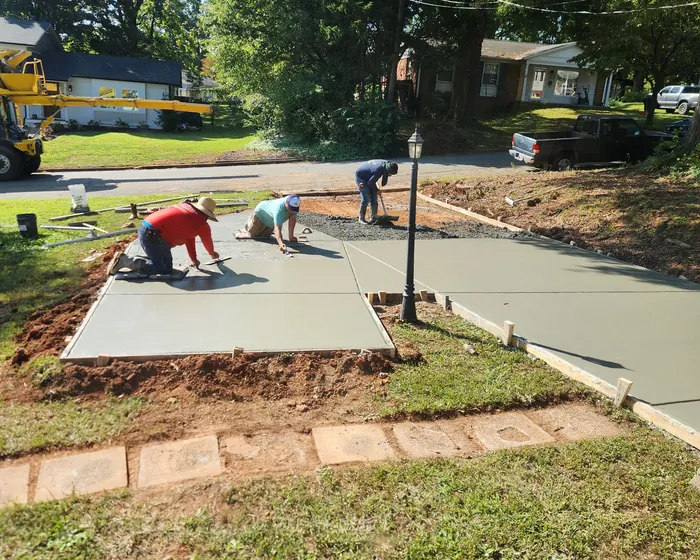 Crew floating and finishing a freshly poured concrete slab